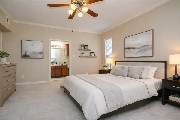 a spacious bedroom with a bed and a chandelier