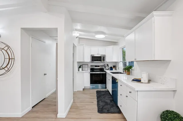 a kitchen with stainless steel appliances a stove refrigerator sink and cabinets