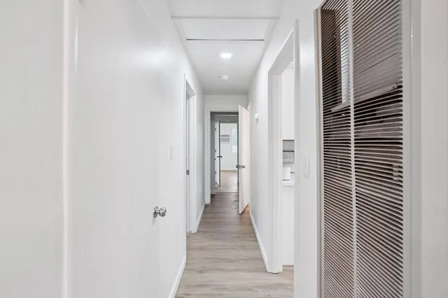 a view of a hallway with wooden floor and staircase