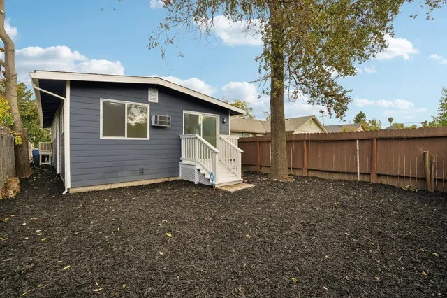 a white house that has tree in front of it
