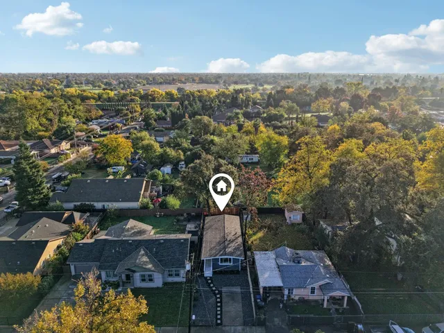 an aerial view of residential house with outdoor space and trees all around