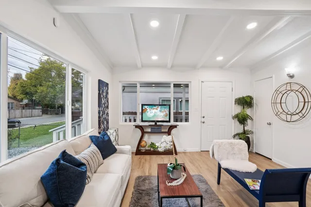 a living room with furniture fireplace and a large window