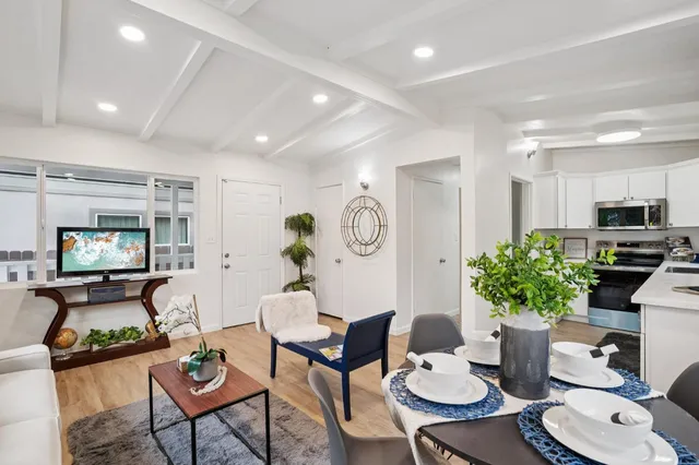 a living room with furniture kitchen and a potted plant