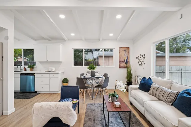 a living room with furniture and view of kitchen