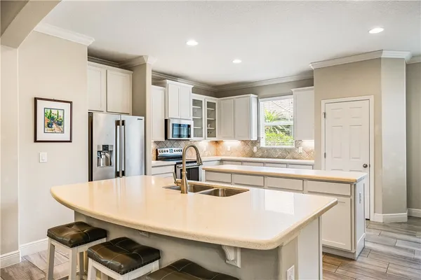 a kitchen with stainless steel appliances a kitchen island a stove a table and chairs