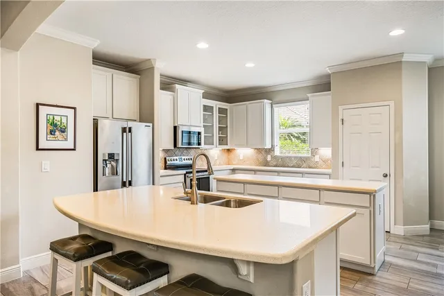 a kitchen with stainless steel appliances a kitchen island a stove a table and chairs