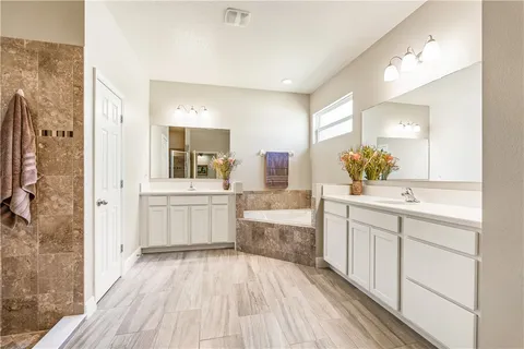 a bathroom with a double vanity sink mirror and shower