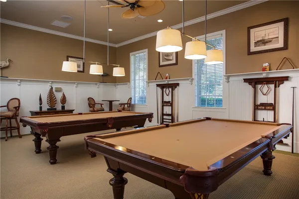 a room with pool table and windows