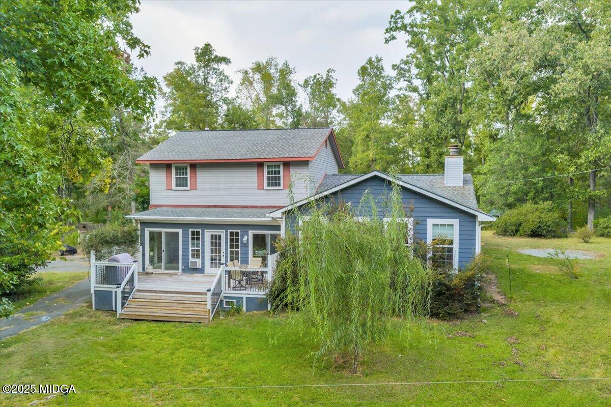 a white house that has a small yard with large trees