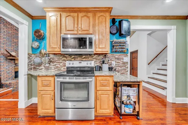 a kitchen with stainless steel appliances granite countertop a stove and a microwave