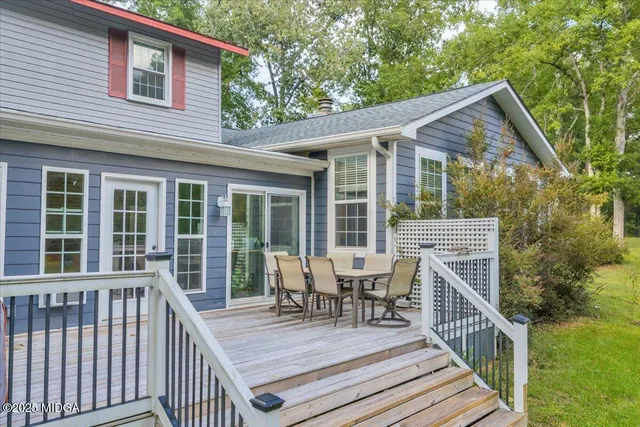 a view of a house with wooden deck and furniture