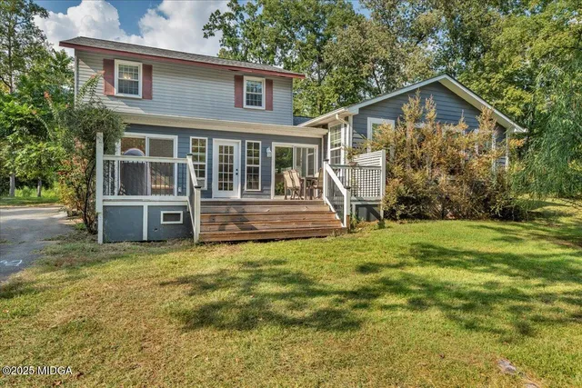 a view of a house with a yard and sitting area