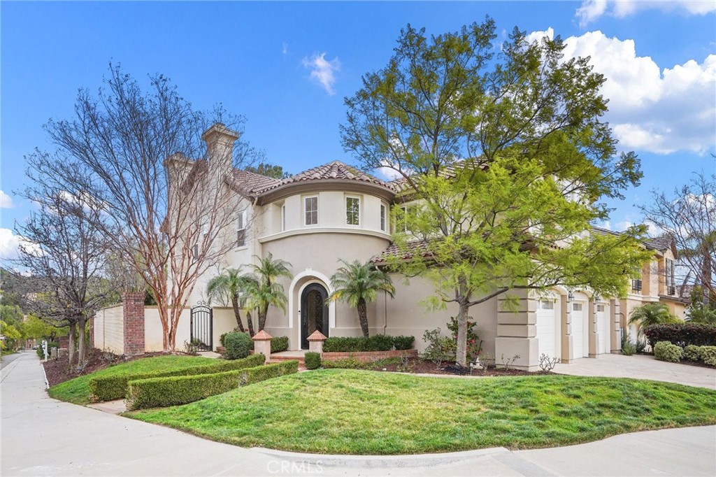 a view of a white house with a big yard and large trees