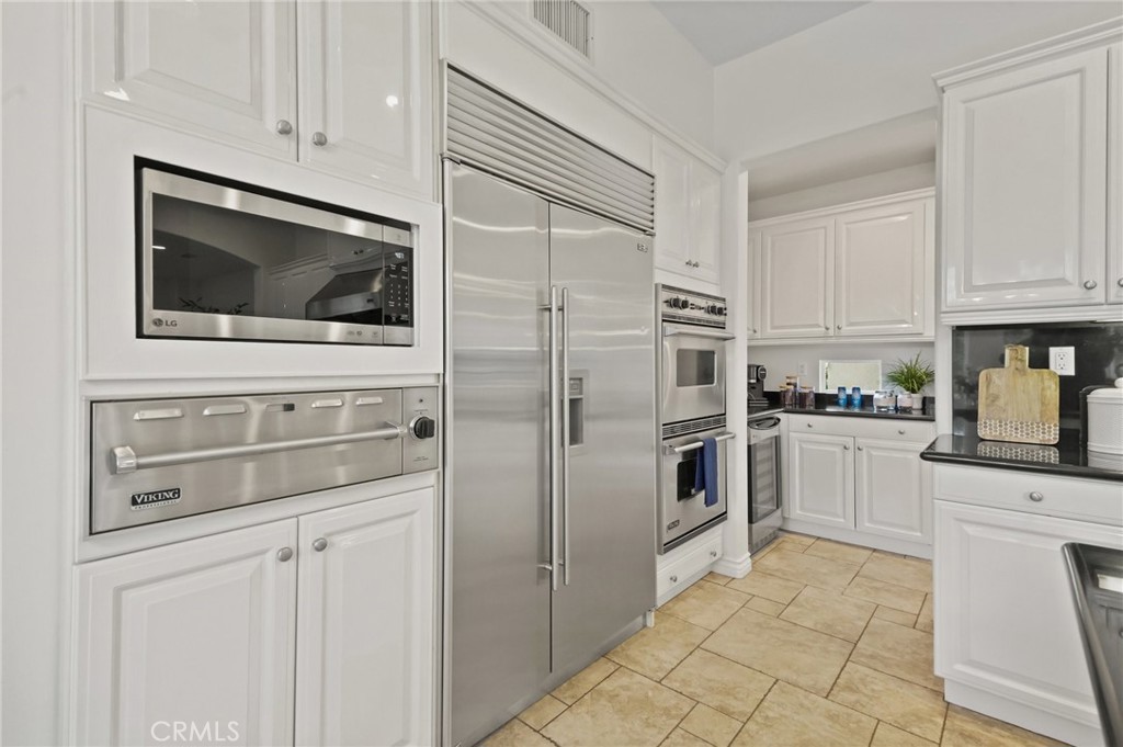 996 Blackbourne Point Oak Park, CA 91377 - Photo 22 of 75 a kitchen with white cabinets and stainless steel appliances