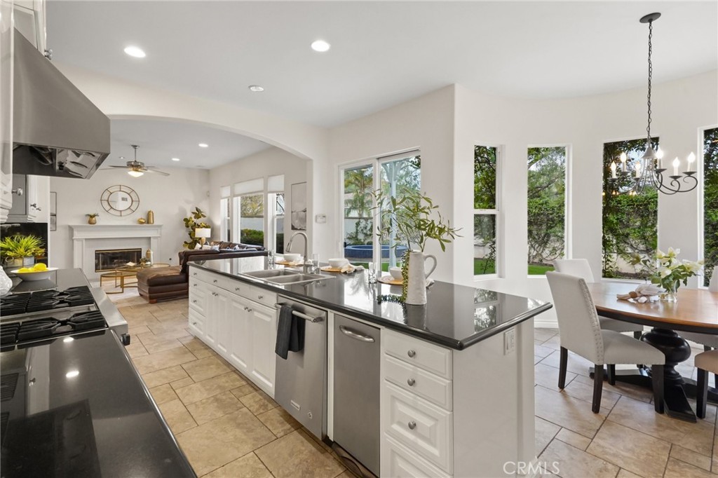 996 Blackbourne Point Oak Park, CA 91377 - Photo 24 of 75 a kitchen with stainless steel appliances granite countertop a stove top oven a sink dishwasher and a dining table with the living room view