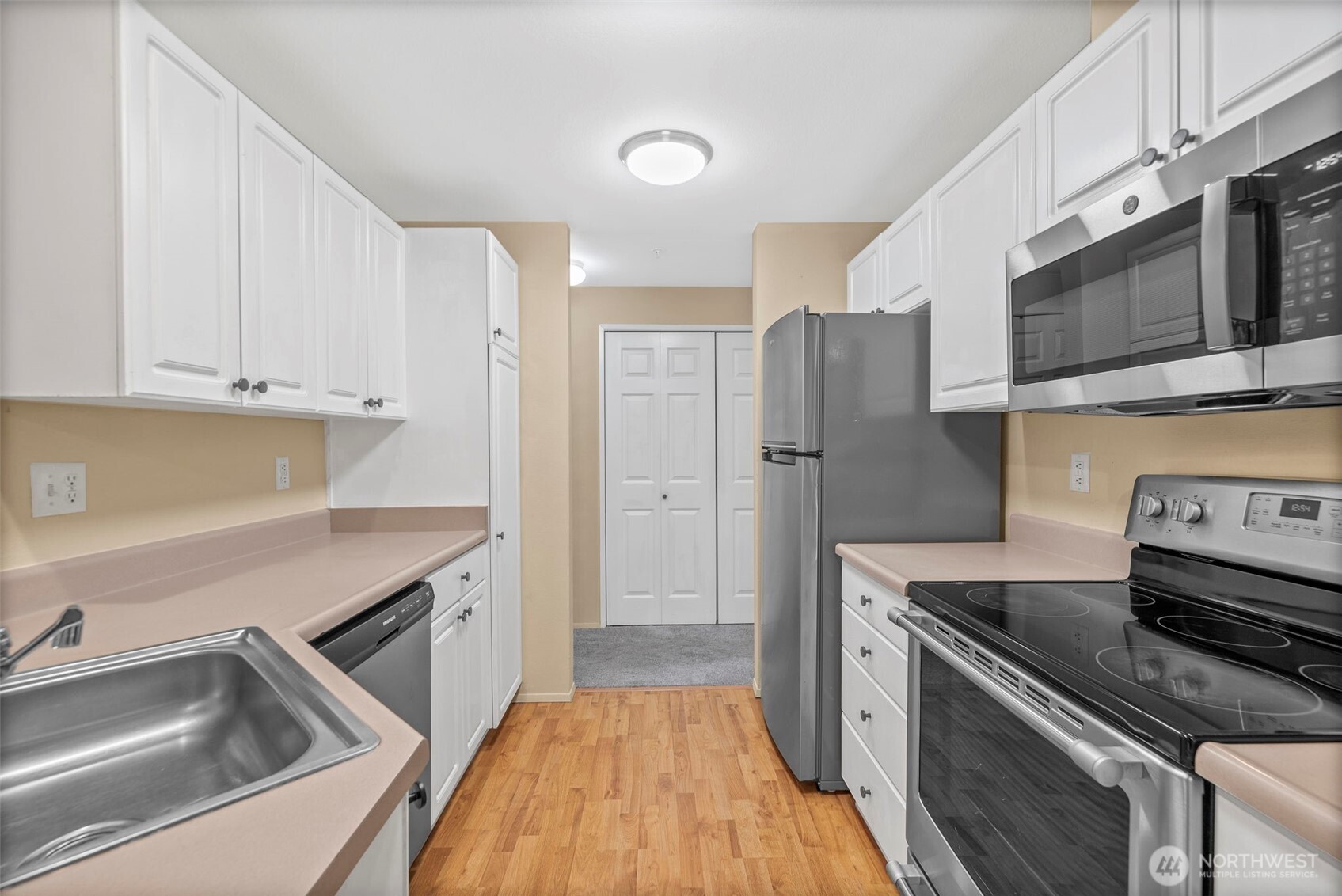 10824 Southeast 170th Street, Unit B103 Renton, WA 98055 - Photo 14 of 31 a kitchen that has a sink stainless steel appliances and cabinets