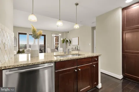 a kitchen with kitchen island granite countertop a sink a center island and stainless steel appliances
