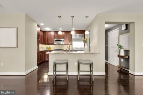 a kitchen with stainless steel appliances granite countertop a stove top oven a sink and a refrigerator