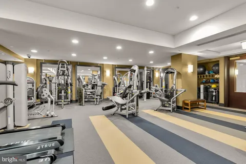 a front view of a building with lot of cars and trees