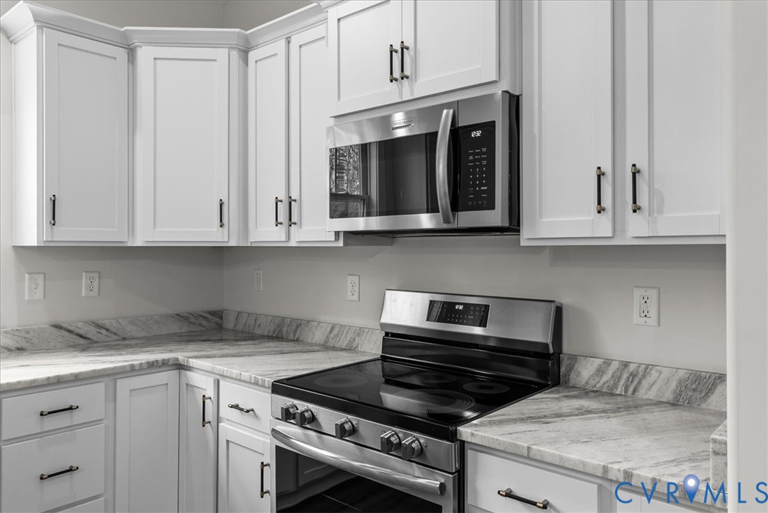 431 Raleigh Avenue South Hill, VA 23970 - Photo 11 of 27 a kitchen with granite countertop white cabinets and stainless steel appliances