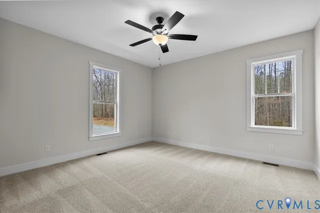 an empty room with windows and ceiling fan