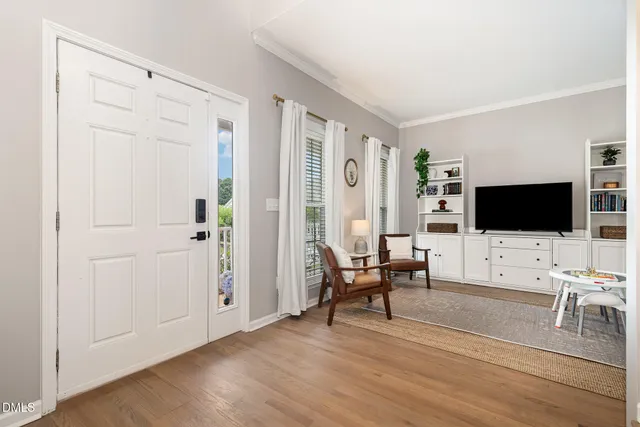 a living room with furniture a flat screen tv and a window