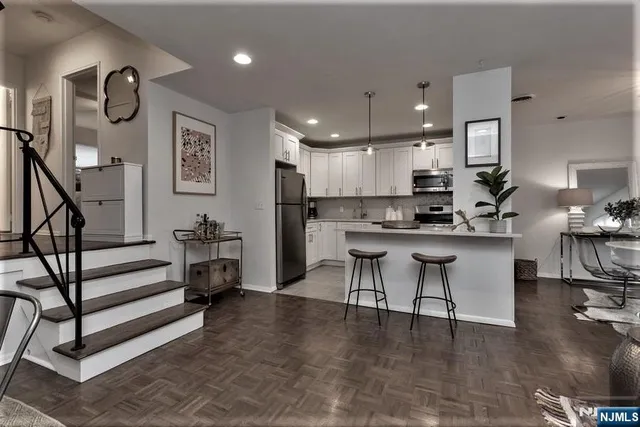 a kitchen with stainless steel appliances kitchen island granite countertop a stove a sink a refrigerator and a cabinets