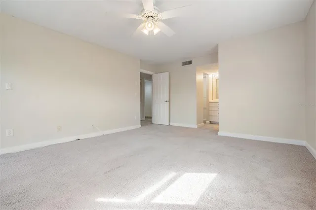 an empty room with fan and entrance