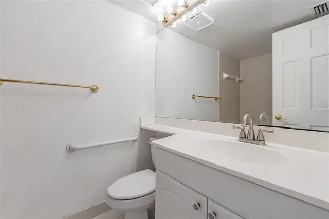 a bathroom with a sink a toilet a mirror and shower