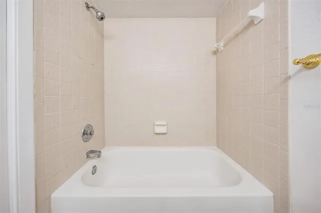 a white bath tub sitting next to a shower