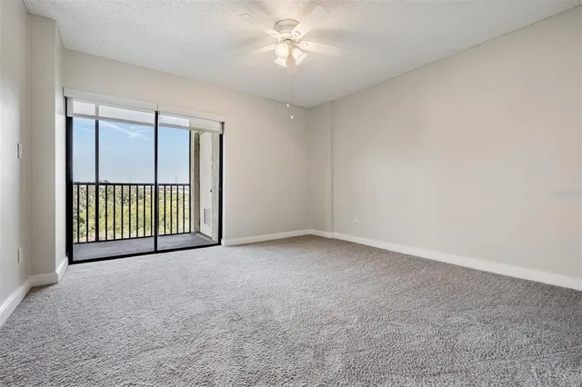 a view of a room with a ceiling fan and window