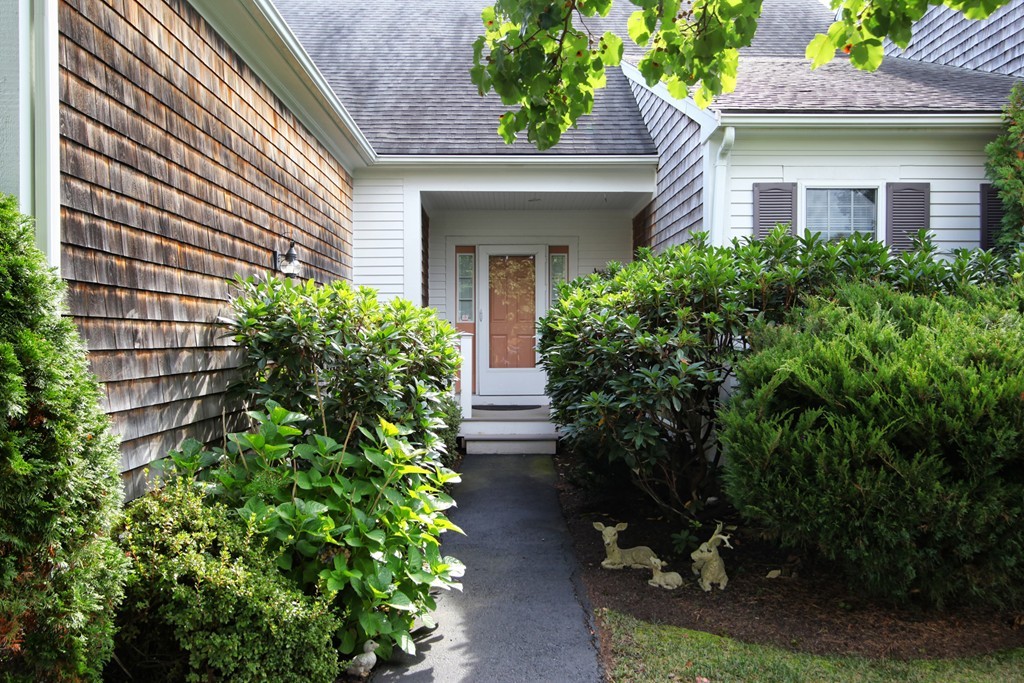 12 Stratford Ridge, Unit 12 Mashpee, MA 02649 - Photo 2 of 27 a view of a house with potted plants and a fountain