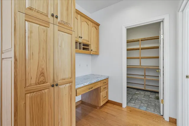 an empty room with windows and chandelier fan