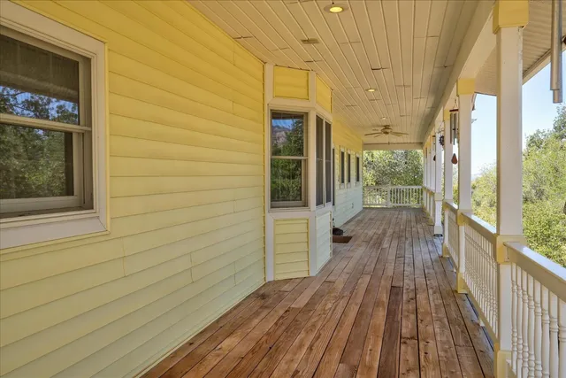 a view of staircase with lots of frames on wall and wooden floor