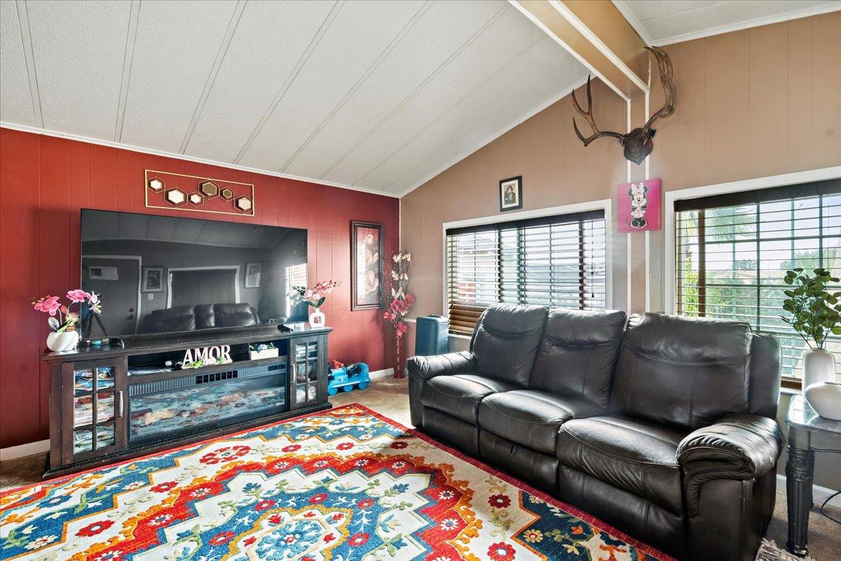 13607 Monte Del Sol, Unit 127 Castroville, CA 95012 - Photo 15 of 27 a living room with furniture a flat screen tv and a floor to ceiling window
