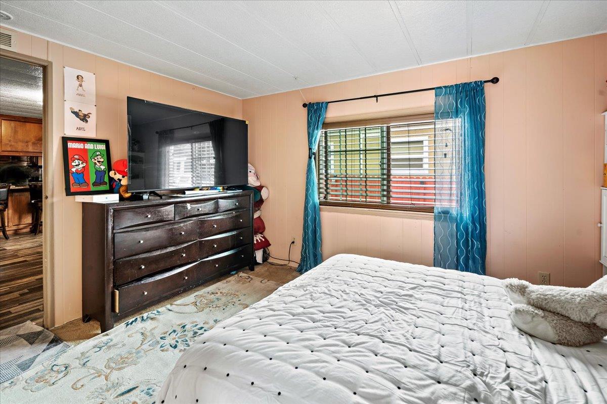 13607 Monte Del Sol, Unit 127 Castroville, CA 95012 - Photo 18 of 27 a bedroom with a bed and a flat screen tv