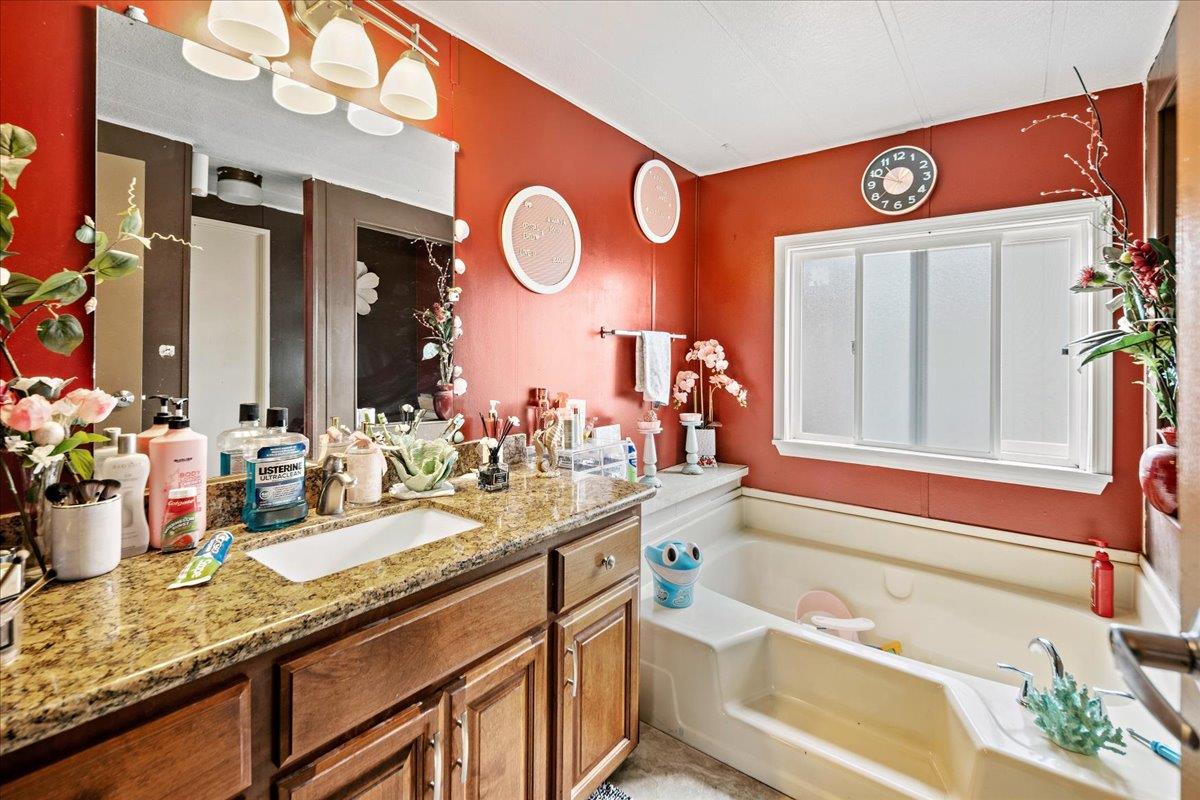 13607 Monte Del Sol, Unit 127 Castroville, CA 95012 - Photo 21 of 27 a bathroom with a granite countertop sink and a mirror