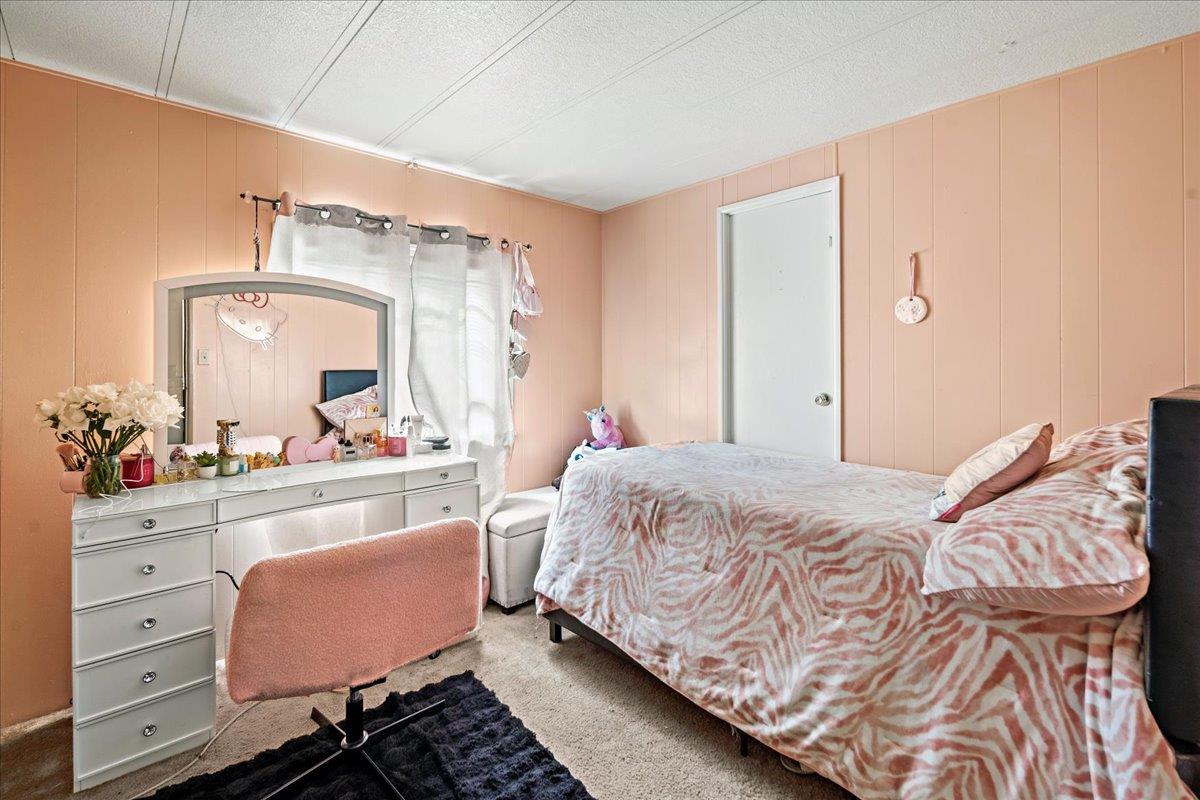 13607 Monte Del Sol, Unit 127 Castroville, CA 95012 - Photo 22 of 27 a bedroom with a bed and a mirror on dresser