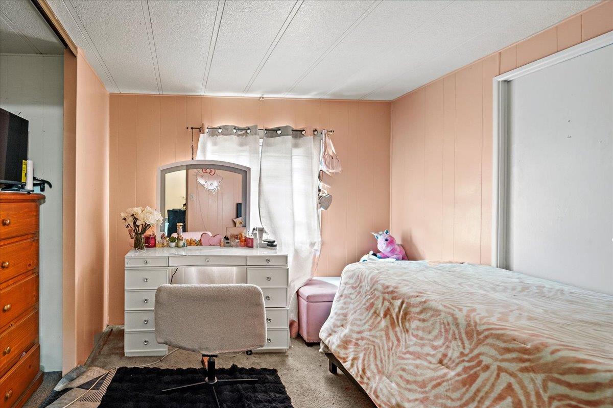 13607 Monte Del Sol, Unit 127 Castroville, CA 95012 - Photo 23 of 27 a bedroom with a bed and wooden floor