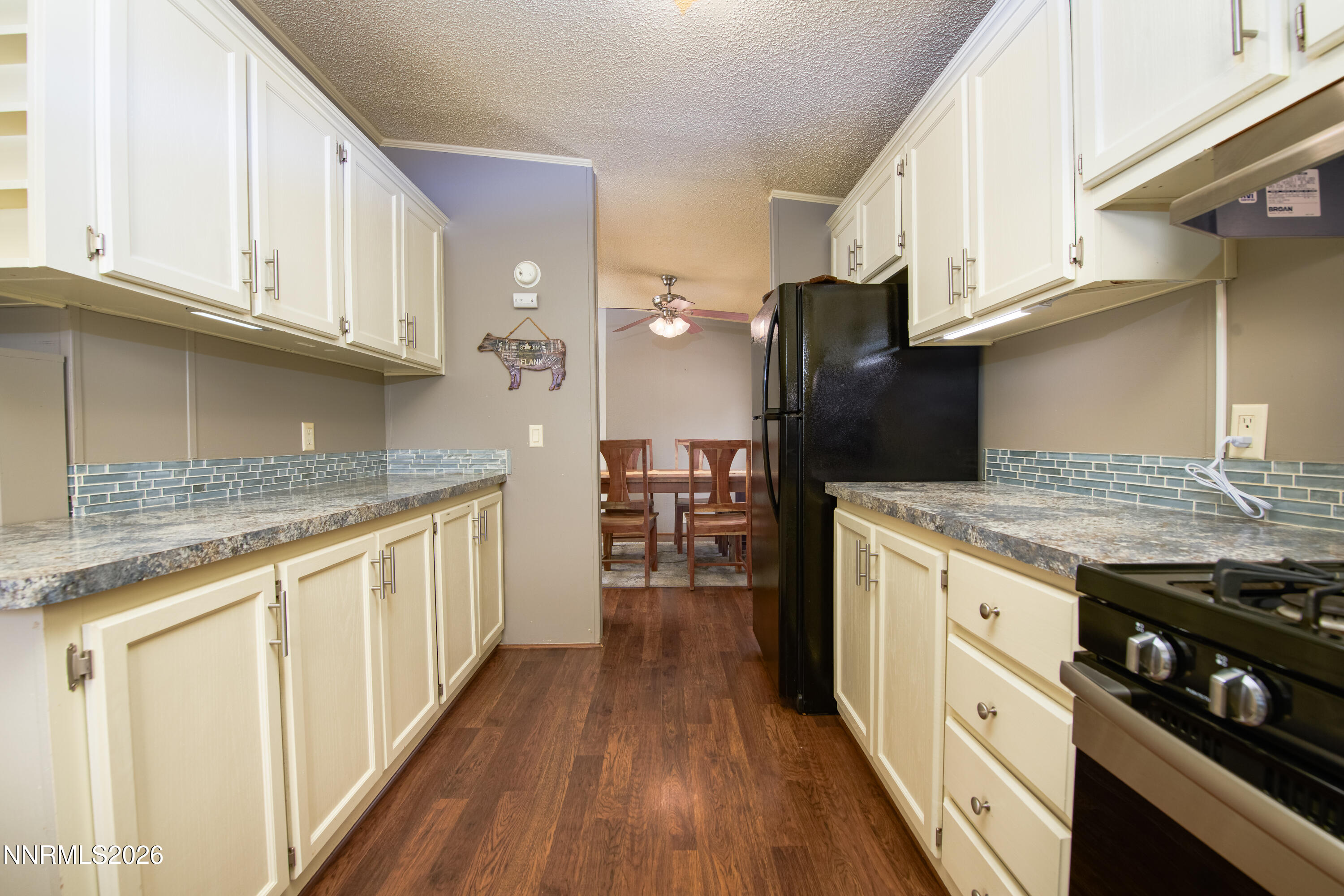 1355 Sandstone Drive Topaz Ranch Estates, NV 89444 - Photo 15 of 57 a kitchen with granite countertop a refrigerator a stove and white cabinets with wooden floor