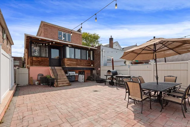 a patio with a table and chairs under an umbrella