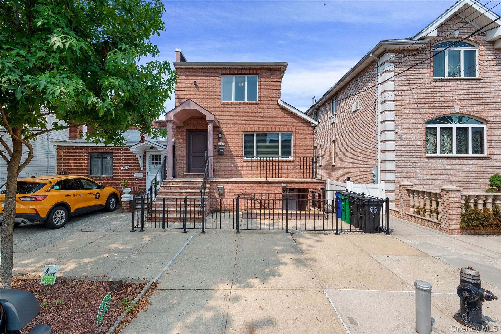 21-34 74th Street Queens, NY 11370 - Photo 2 of 20 a front view of a house with parking space