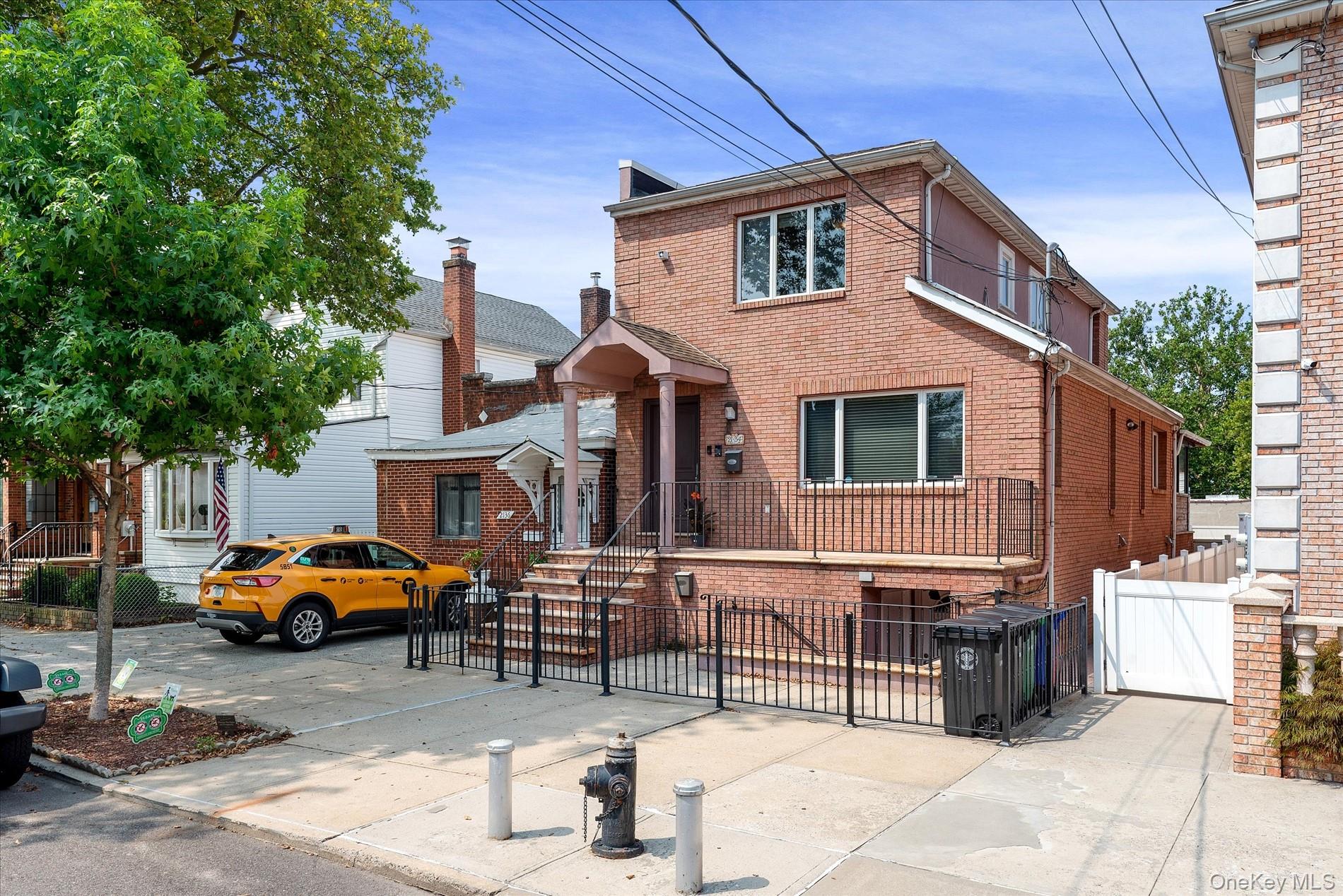 21-34 74th Street Queens, NY 11370 - Photo 3 of 20 a front view of a house with cars parked