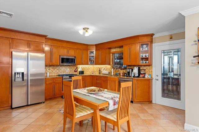 a kitchen with stainless steel appliances granite countertop a refrigerator and a stove top oven