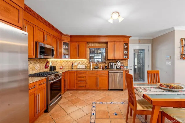 a kitchen with stainless steel appliances granite countertop a stove top oven a sink dishwasher a dining table and chairs with wooden floor