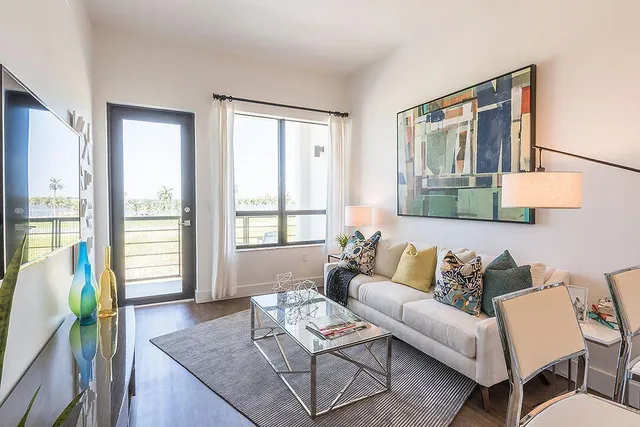 a living room with furniture and floor to ceiling windows