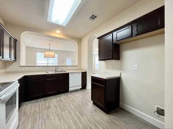 a kitchen with a refrigerator and a wooden cabinets