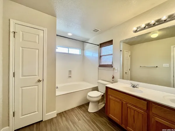 a bathroom with a double vanity sink a toilet and a large mirror