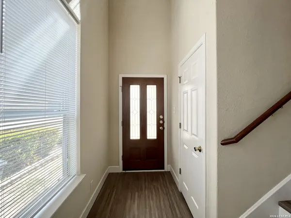 a view of a hallway with wooden floor and stairs