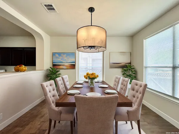 a dining room with furniture potted plants and wooden floor